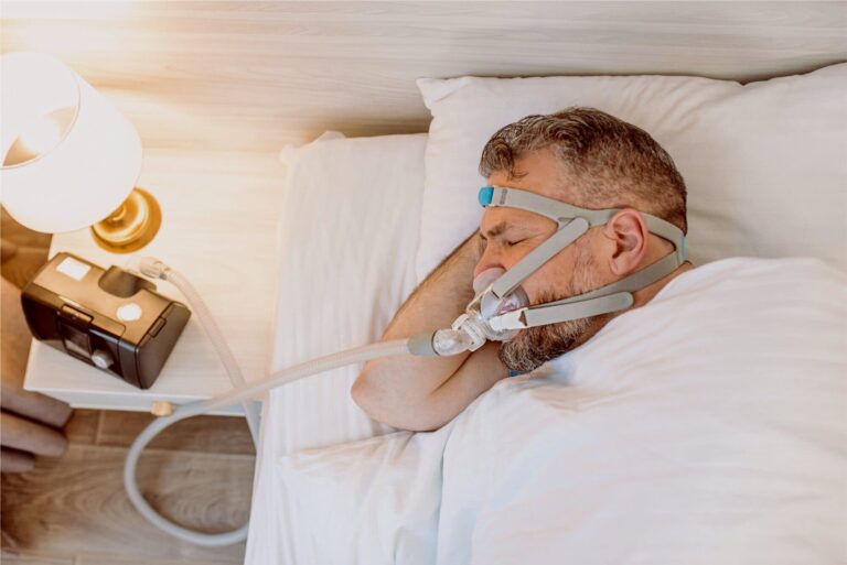 Sleep apnea patient sleeping with CPAP 140KB 768x513